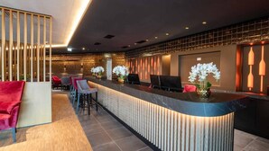 A reception area with a curved counter, red chairs, and a wooden partition.