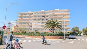 A multi-story residential building with balconies, a palm tree, and a no entry sign. - Apartment 'Sea and Charm' with Shared Pool, Wi-Fi, and Air Conditioning (Miami Platja)