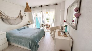 A bedroom with a bed, desk, chair, and a hammock. - Apartment 'Sea and Charm' with Shared Pool, Wi-Fi, and Air Conditioning (Miami Platja)