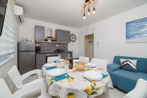 A compact living space with a dining area, kitchenette, and a sofa. - Modern apartment for 4-5 persons with terrace, sea view (Dramalj)