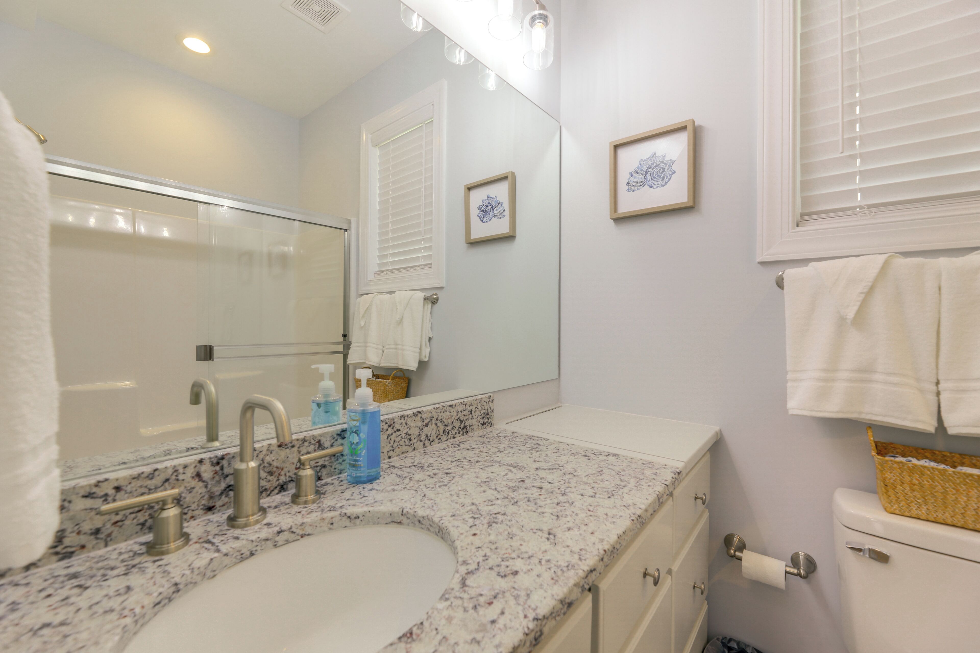 A bathroom with a sink, mirror, towel rack, and toilet.