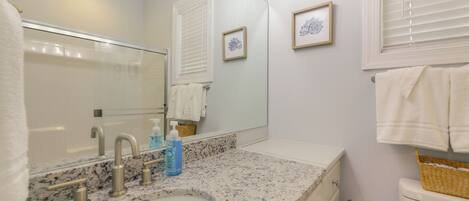 A bathroom with a sink, mirror, towel rack, and toilet.