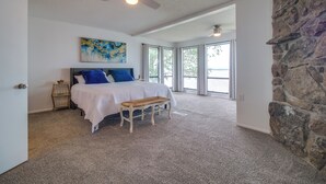 A bedroom with a bed, bench, and artwork on the wall. - Water-view Patio, Near Golf! Port Duncan Retreat (Afton)