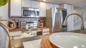 A modern kitchen with stainless steel appliances, a large sink, and a decorative plant. - Water-view Patio, Near Golf! Port Duncan Retreat (Afton)