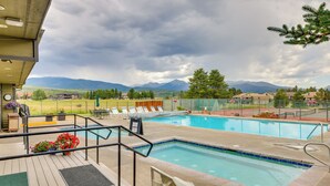 A pool area with two swimming pools, a deck with lounge chairs, and a view of mountains in the background. - Luxury WP Mtn Cabin, Free Shuttle, Views & Garage (Fraser)