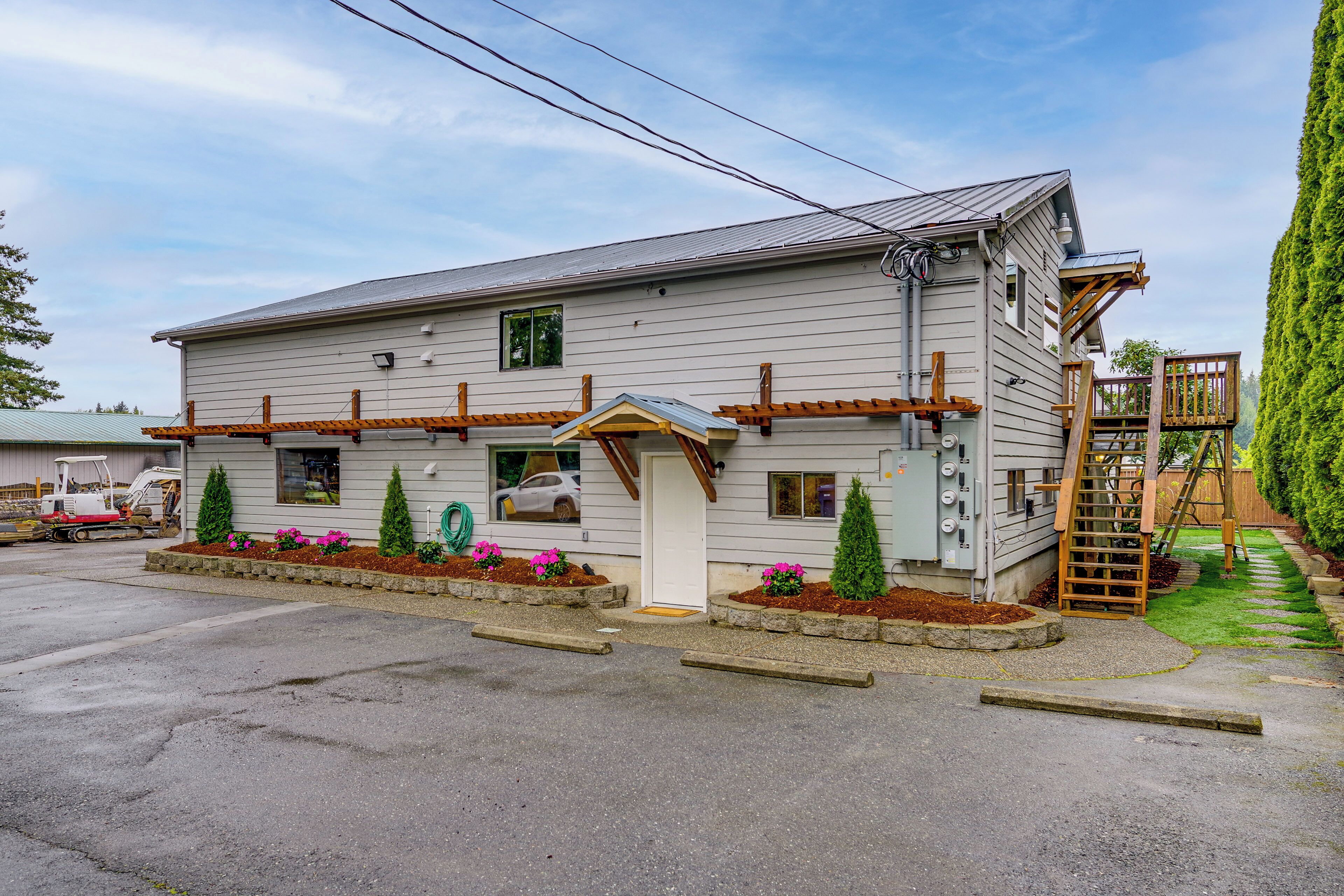 A two-story building with a front porch, a garage, and a small deck.