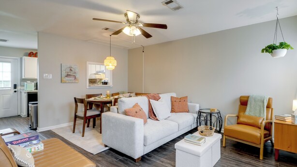 A modern living room with a white sofa, a brown leather chair, a white coffee table, and a ceiling fan. - Walk to Park w/ Pond, Trails & More! Sherwood Unit (Sherwood)