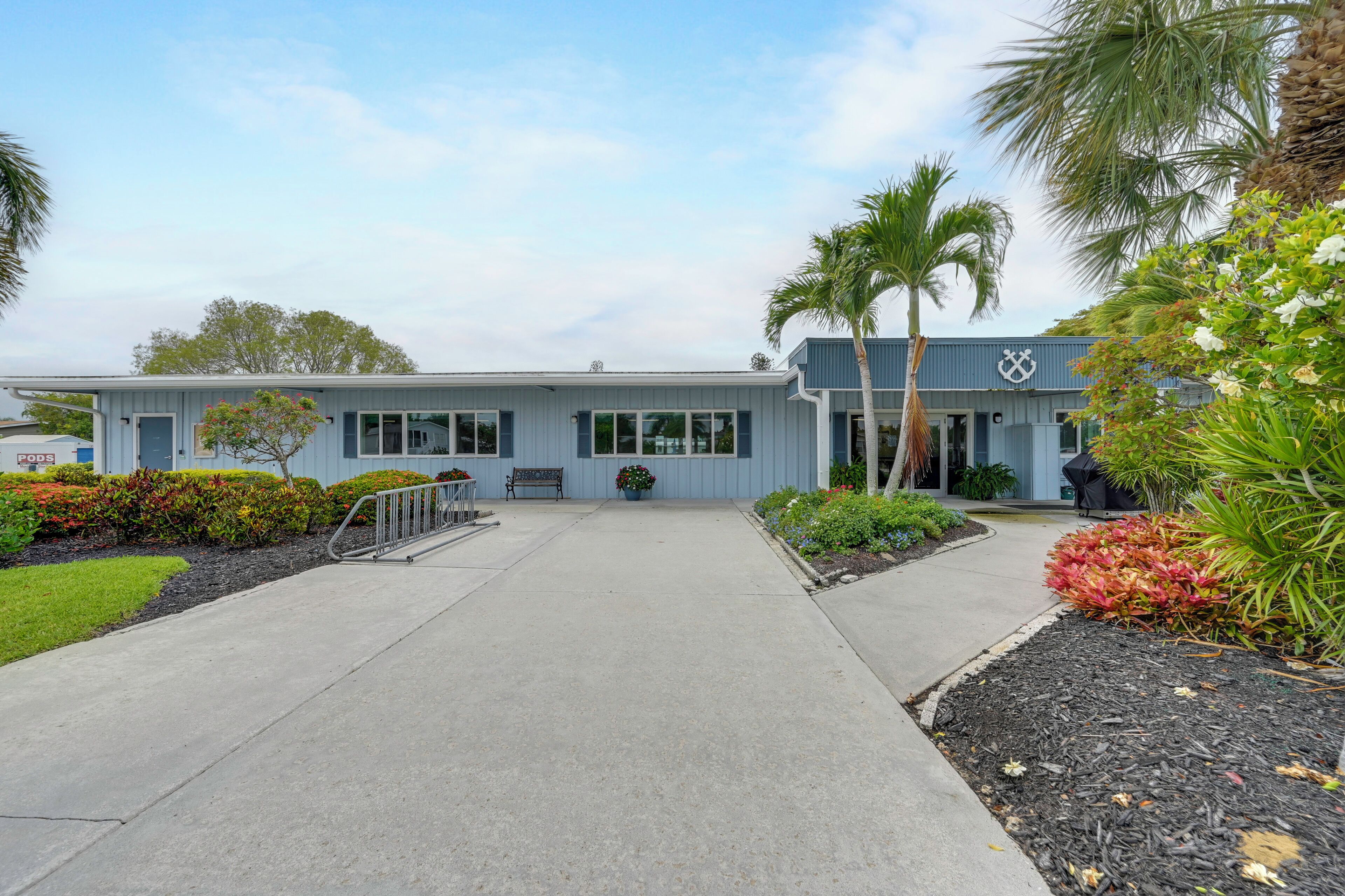 A building with a blue exterior, a front entrance, and a pathway leading to it.
