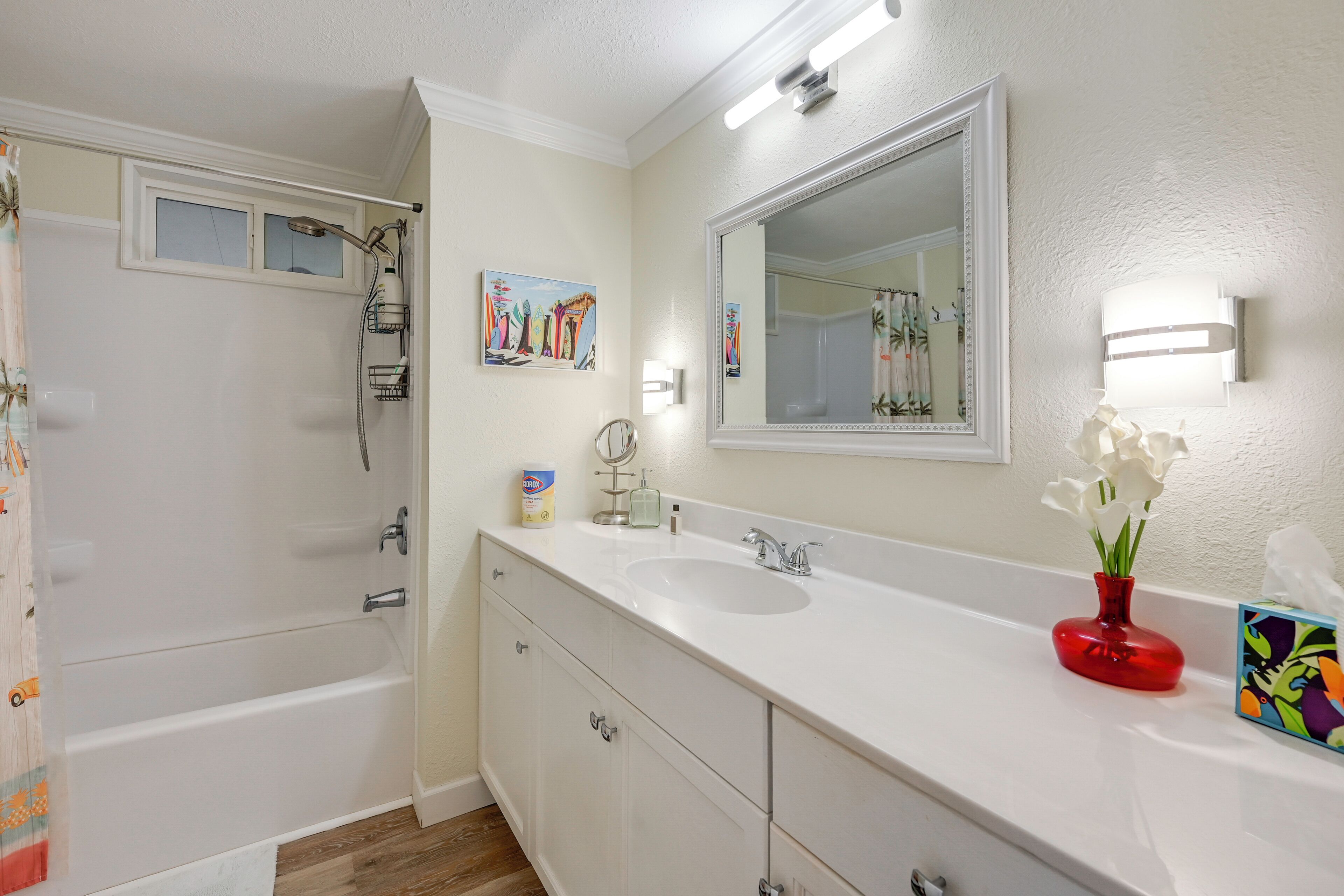 A bathroom with a bathtub, a sink, a mirror, and a shower.