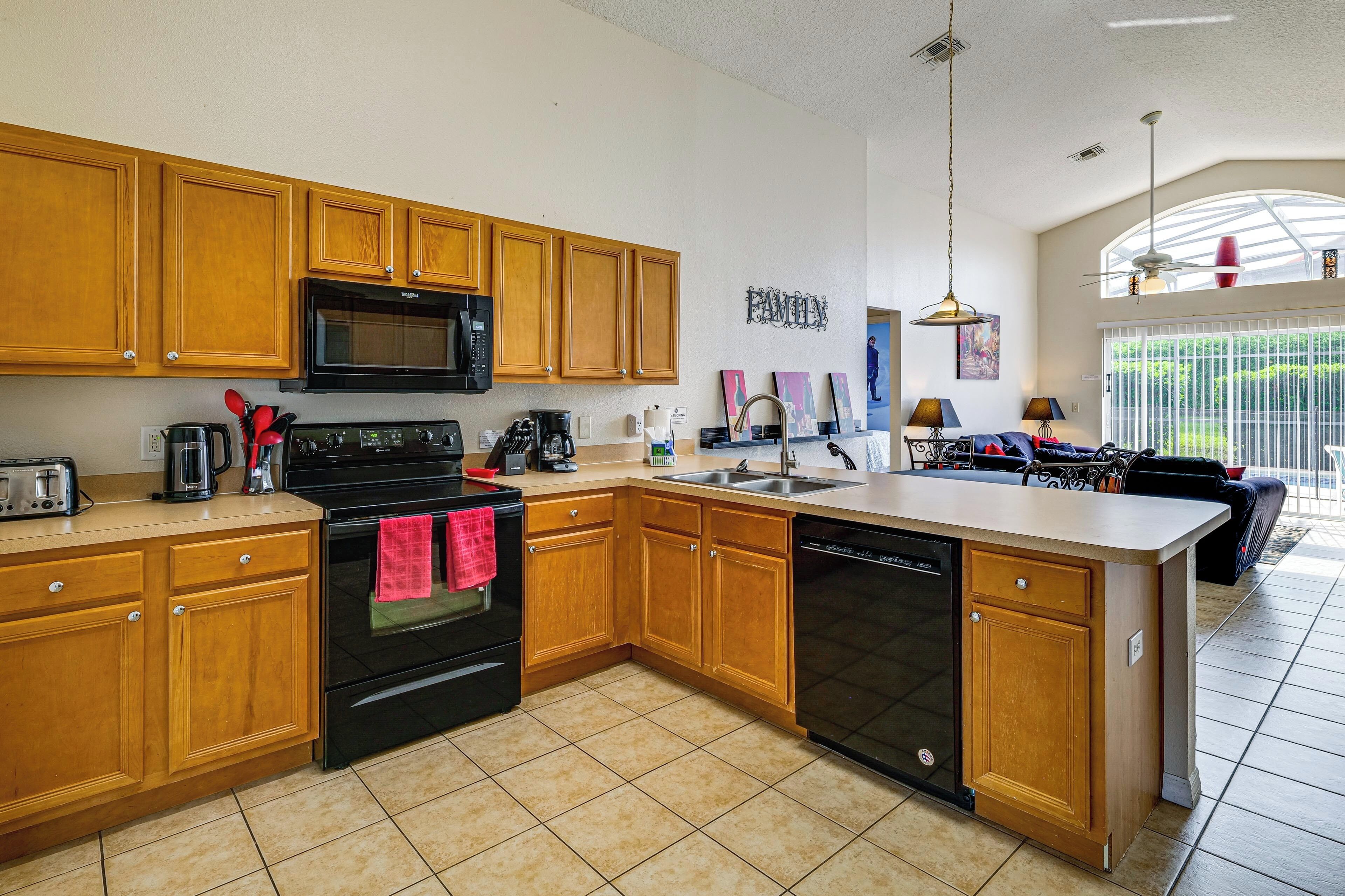 A kitchen with wooden cabinets, a microwave, stove, and dishwasher.