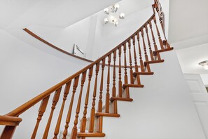 Eine Treppe mit Holzspindeln und einer weißen Wand.