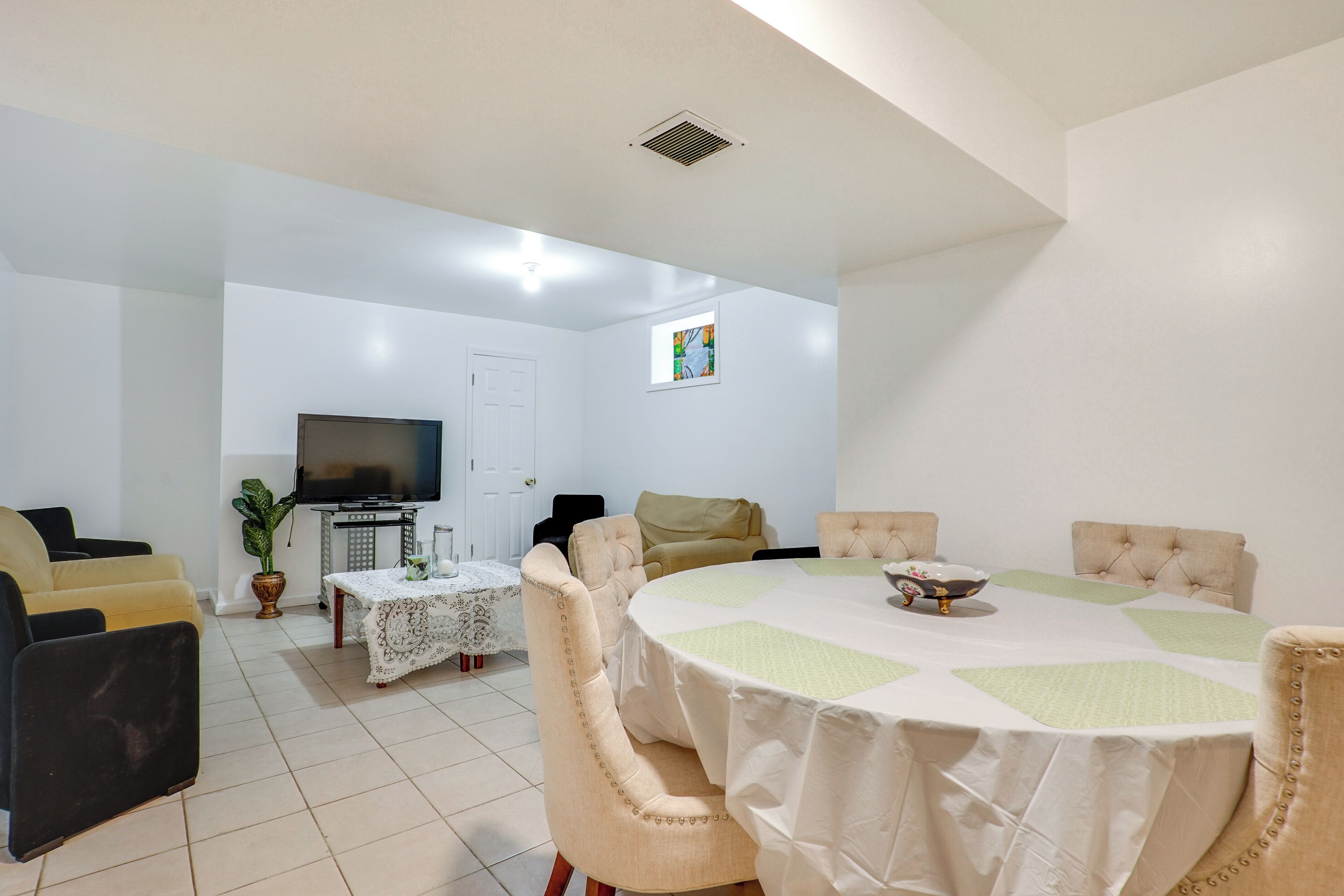 Un salon avec un téléviseur, un canapé et une table à manger.