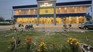 A hotel named 'LIMELIGHT' with a modern facade, large windows, and a well-maintained garden in front. - LIMELIGHT Hotel & Restaurant (Rishikesh)