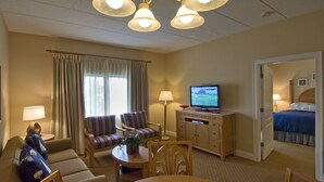 A hotel room with a sofa, armchairs, a dining table, a TV, and a bed. - The Best Unit at the Best Resort during the Best Week on Cape Code (Yarmouth)