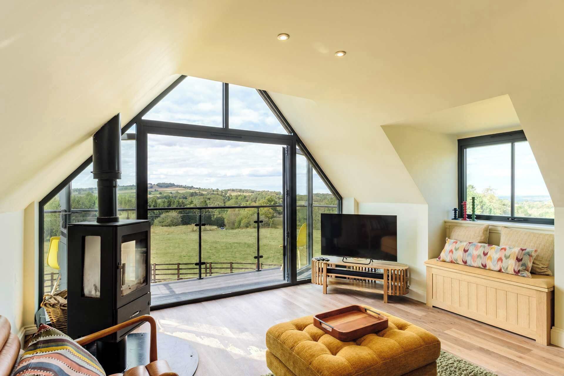 Un loft amplio con un tragaluz grande, chimenea, televisor de pantalla plana y una zona de estar acogedora.