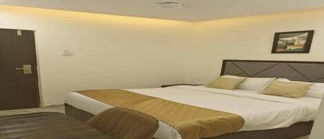A hotel room with a bed, a desk, and a chair.