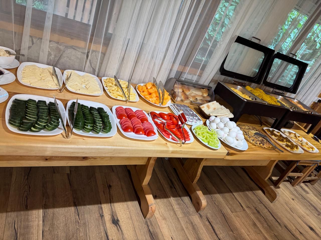 A buffet table with various food items and utensils.