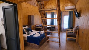 Una habitación de madera con una cama, un escritorio, una silla y una escalera.