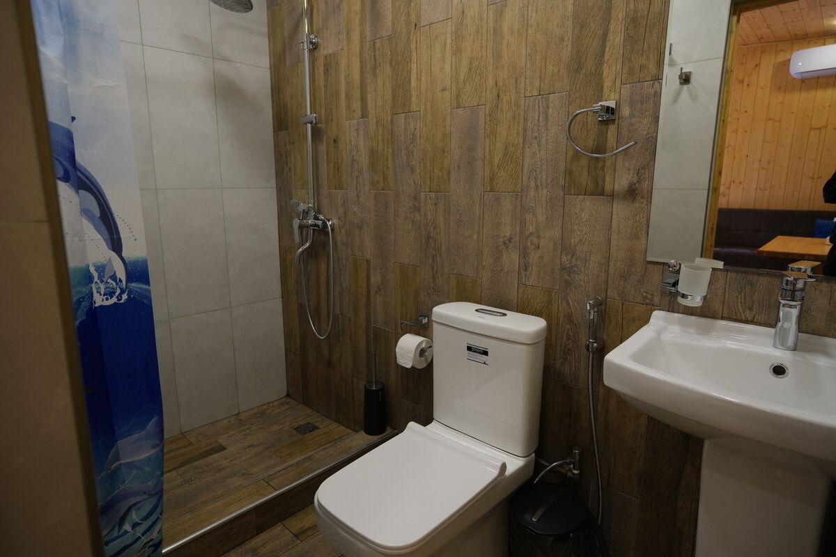A bathroom with a shower, toilet, and sink.
