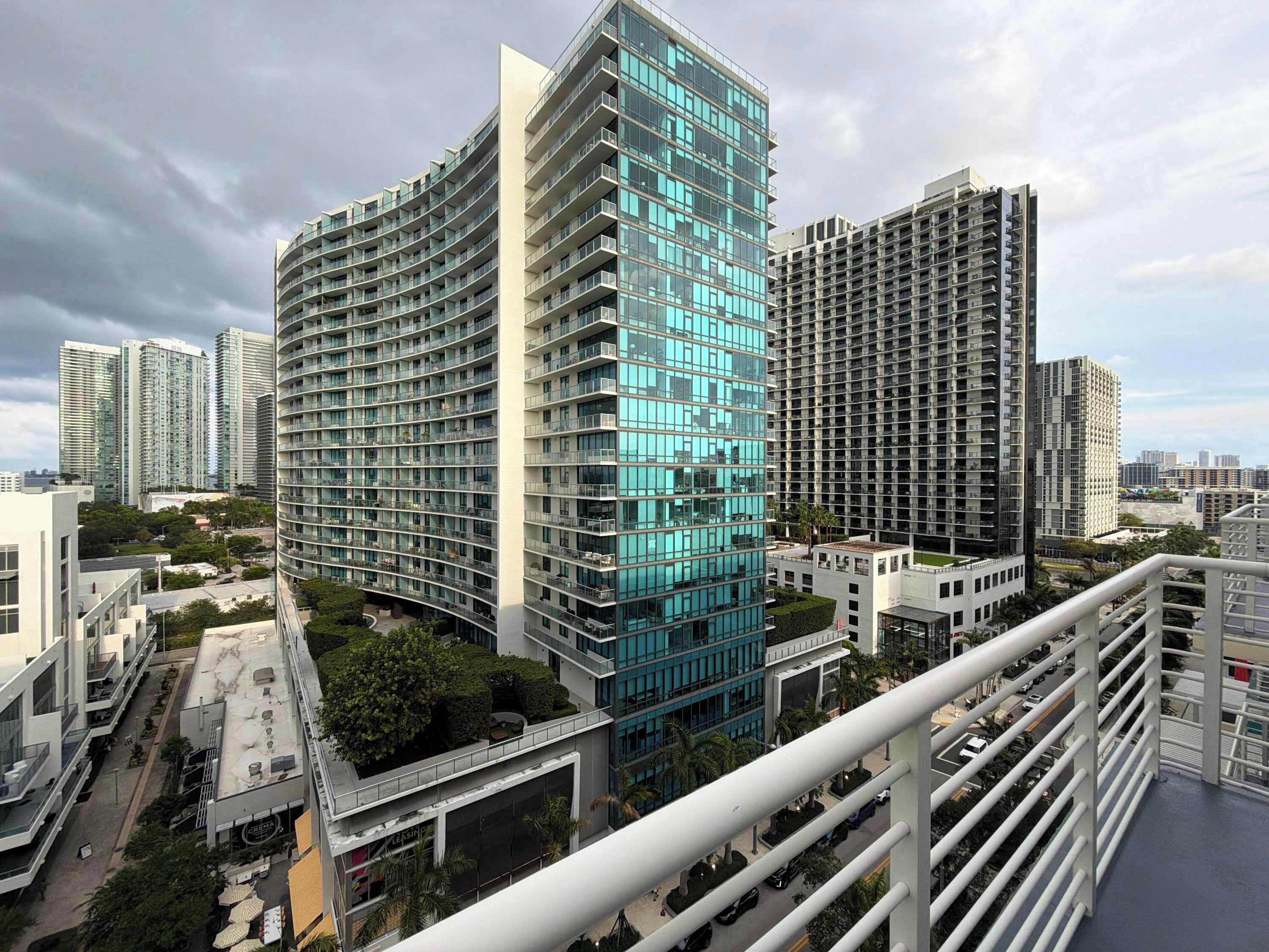 Un immeuble de grande hauteur doté de nombreux balcons, présentant un design architectural moderne et s’intégrant dans un environnement urbain.