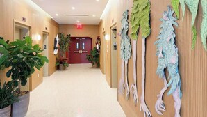 A hallway with wooden paneling, a red door, and potted plants. - Studio in Midtown | Standard Miami - Pool & Gym (Miami)