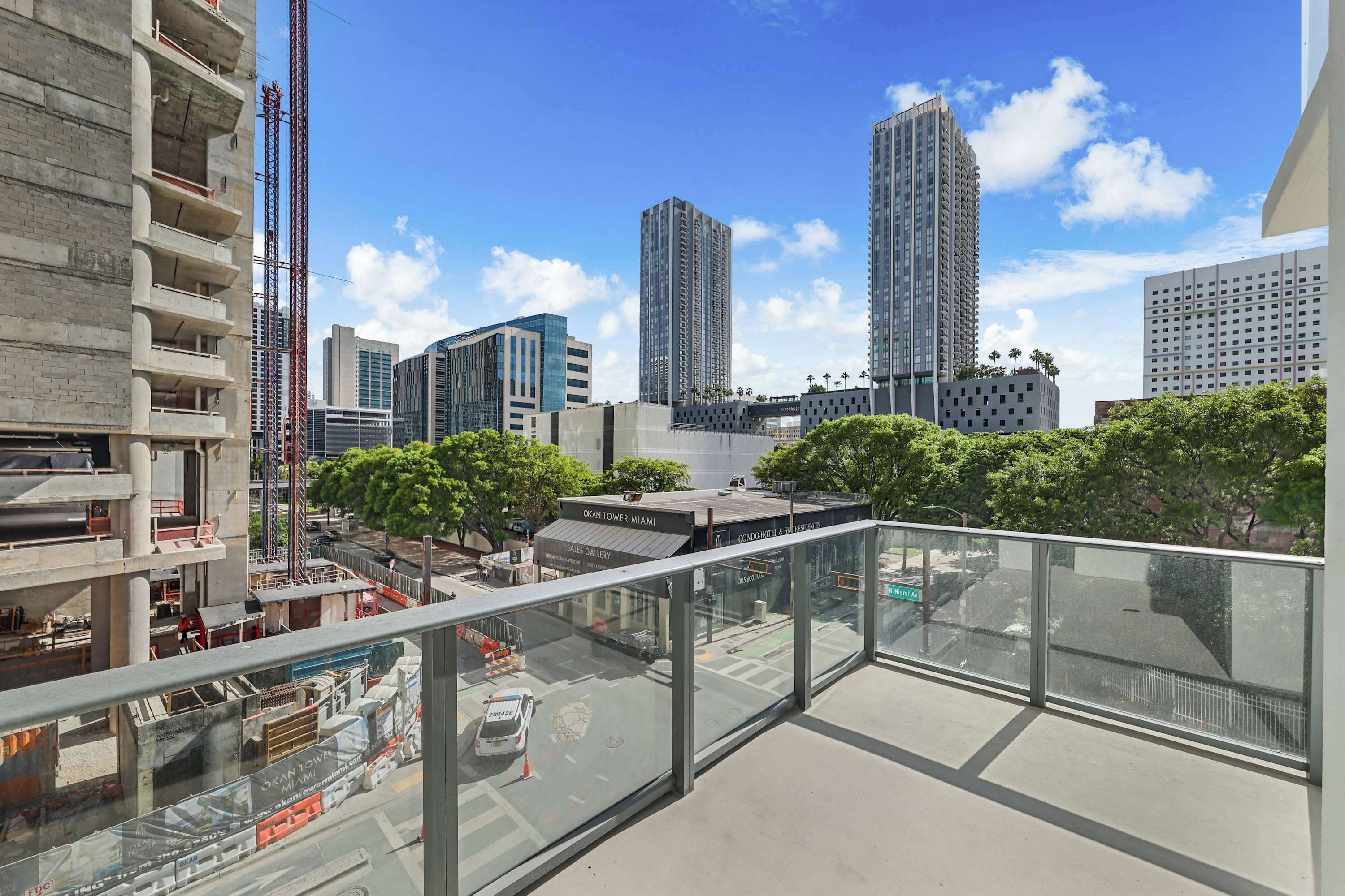 A high-rise building with a glass balcony overlooking a cityscape.