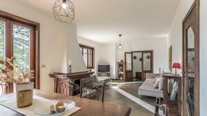 Amplia sala de estar con mesa de comedor, sofá y televisor.