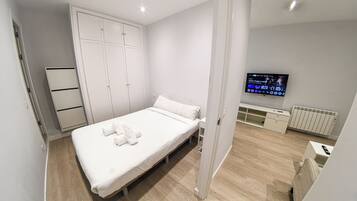 Tabla de planchar con plancha, internet y ropa de cama