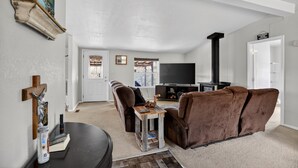 Ein Wohnzimmer mit braunem Sofa, einem Holztisch, einem Fernseher und einem Kamin.