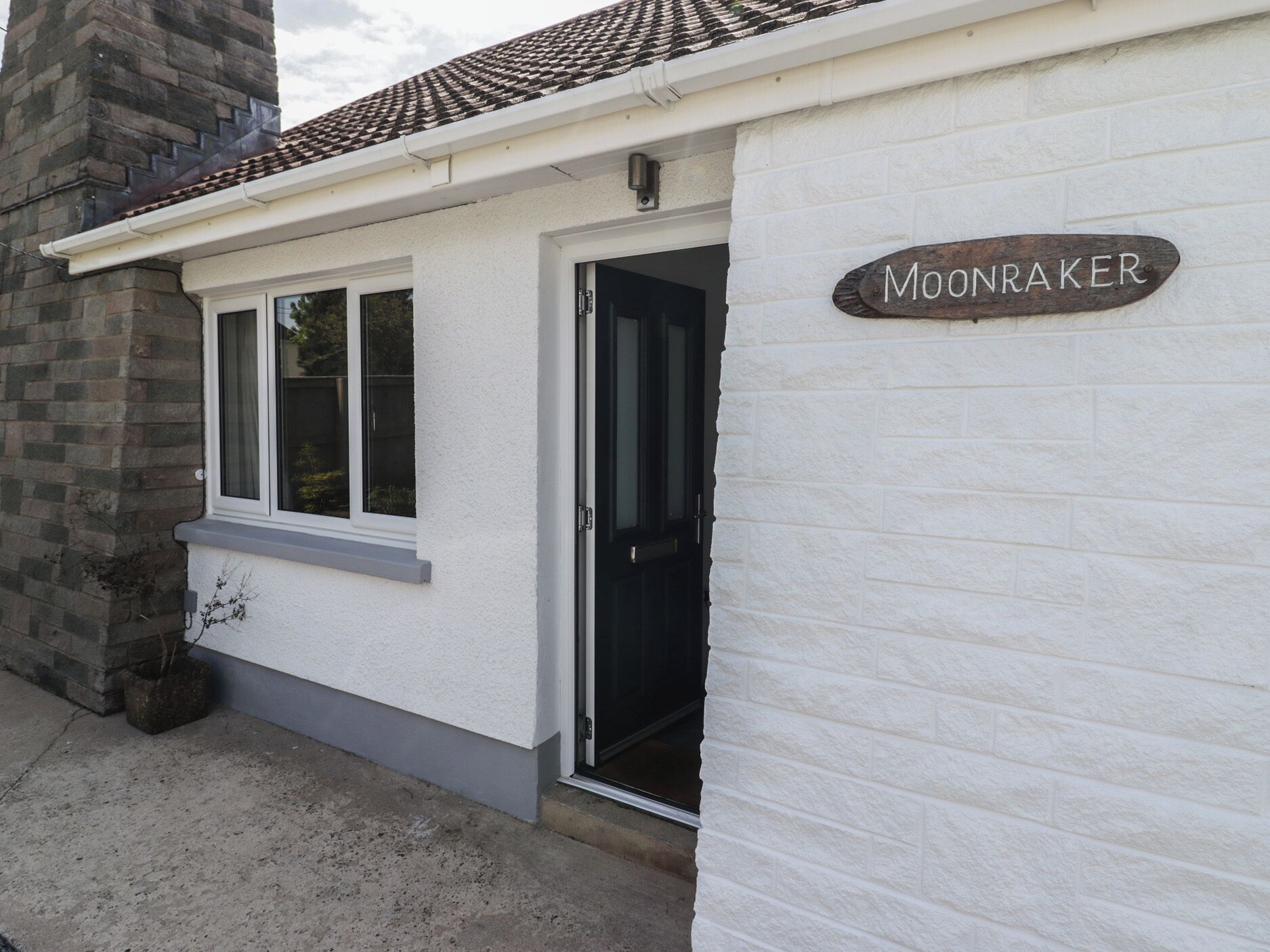 A building with a sign reading 'MOONRAKER' on a white brick wall.