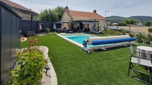 A backyard with a swimming pool, artificial grass, and a house with a red roof. - Le Clos Carion A little corner of paradise just a stone's throw from the town center (Autun)