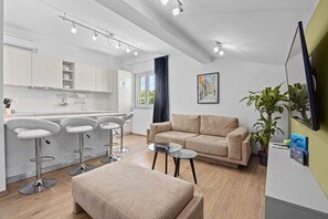 Ein moderner Wohnbereich mit einer Couch, einem Couchtisch und einer Bar mit Barhocker.