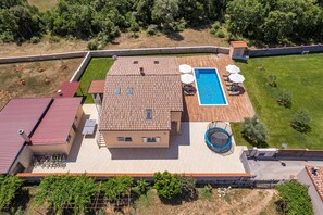 Um imóvel residencial com piscina, área de estar no pátio e jardim.