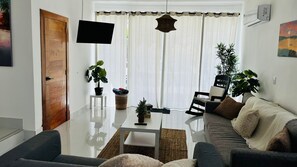 A modern living room with a sofa, coffee table, and potted plants. - Tranquil Villa with Private Pool in Punta Cana (Punta Cana)