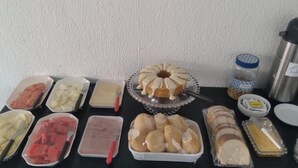 Ett buffébord med olika sorters mat och en sockerkaka.