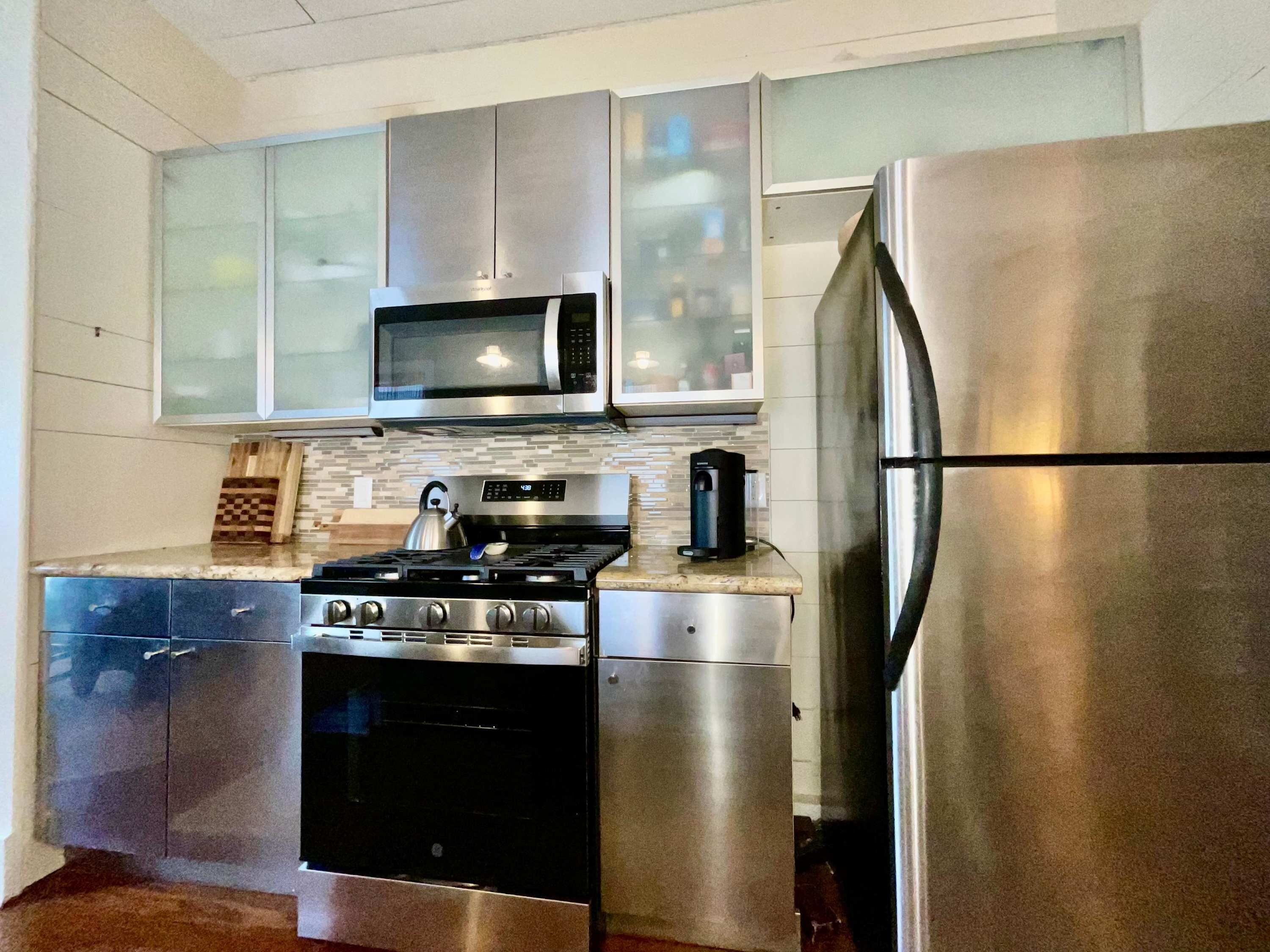 A modern kitchen with stainless steel appliances, including a stove, oven, microwave, and refrigerator.