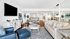 Un salon moderne avec un canapé, une table basse et un téléviseur.