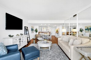 A modern living room with a sofa, coffee table, and TV. - Newly updated 2 Bedroom villa with peaceful ocean views (Hilton Head Island)