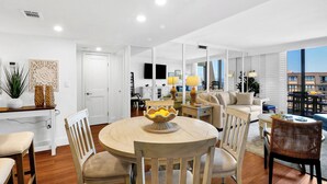 Un salon moderne comprenant une table ronde, des chaises, un canapé et un coin repas avec une table et des chaises.