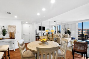 A modern living room with a round table, chairs, a sofa, and a dining area with a table and chairs. - Newly updated 2 Bedroom villa with peaceful ocean views (Hilton Head Island)