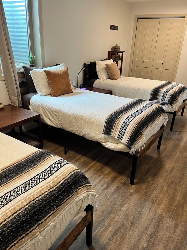 A room with two beds, a desk, a lamp, and a door. - Peaceful & Relaxing Farm Home (Marshall)