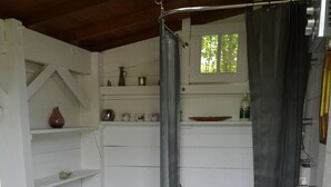 A bathroom with a shower, sink, and decorative flower mats. - TIPI TENT (Callen)