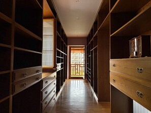A narrow hallway with wooden cabinets and drawers, leading to a balcony with a view of buildings. - Villa Las tres Mares 6826 (Noja)