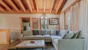 A cozy living room with a sectional sofa, a coffee table, and a wooden ceiling. - The Golden Bend Cozy Stay (Truckee)