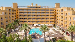 A hotel with multiple balconies, a central swimming pool, and palm trees. - Hotel Esra Family Suite - All inclusive (Didim)