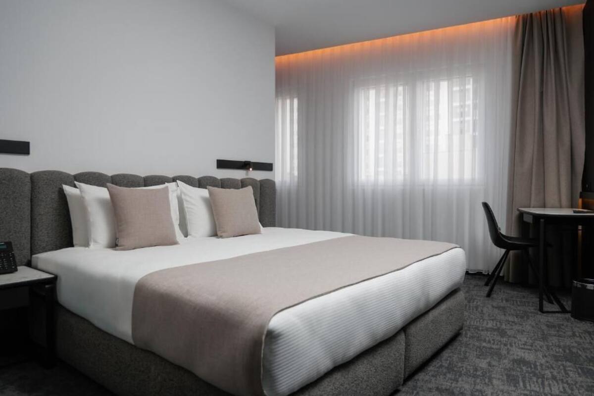 Ein Hotelzimmer mit einem großen Bett, einem Schreibtisch und einem Stuhl.