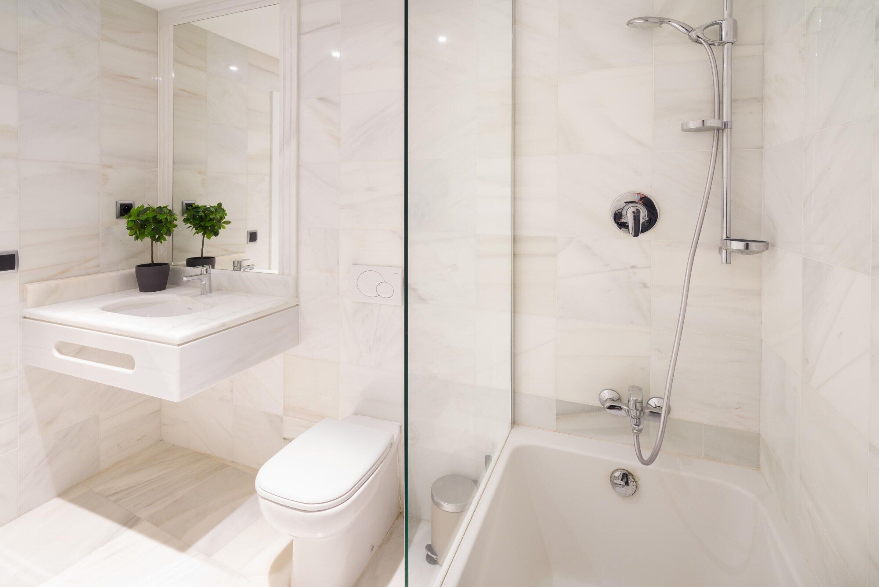 Une salle de bain moderne équipée de toilettes, d’un lavabo et d’une douche.