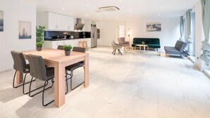 Un interno moderno con zona pranzo, cucina e angolo salotto.