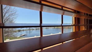 A wooden bench with a view of a calm lake and dock. - Expansive Luxury at The Waterfront on Green Lake (Green Lake)