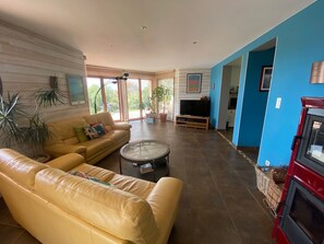 Ein Wohnzimmer mit einer Couch, einem Couchtisch, einem Fernseher und einem Kamin.